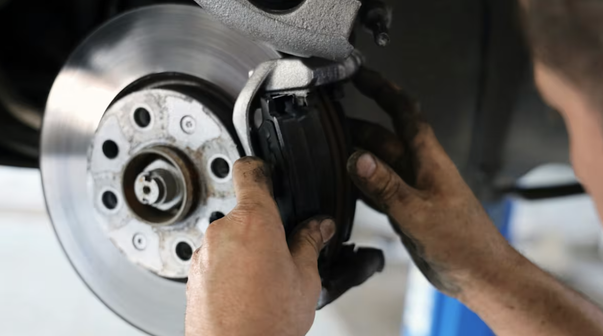 Mechanic removing pads and caliper.